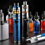 Electronic cigarettes and bottles with vape liquid on black background